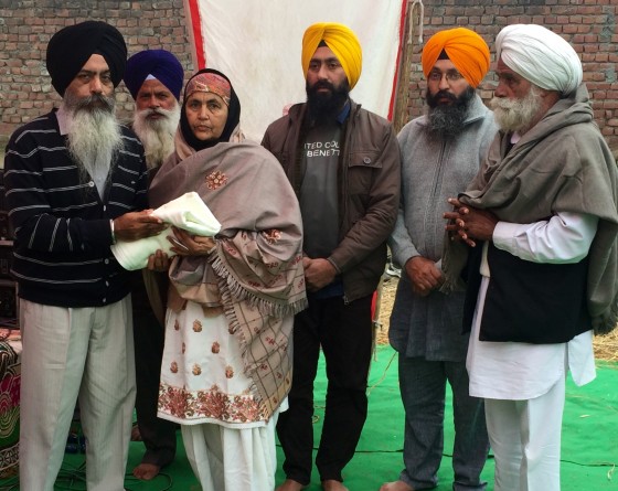 Kanwar Pal Singh presenting robe of honour to Simarjit Kaur wife of Sukhdev Singh Ballagan