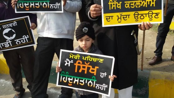 A Sikh child holds a placard declaring his identity as a Sikh