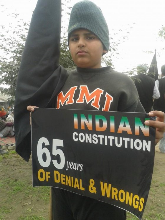 A Sikh child holds a placard during a protest organized by Sikh organizations