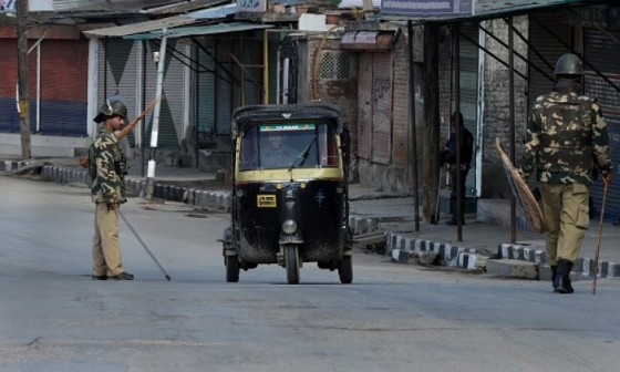 Indian paramilitary troopers stop an auto-rickshaw driver during a curfew in Srinagar on February 9, 2015