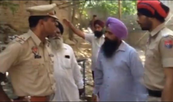 Ravinderjit Singh Gogi in police custody; at left is the police officer accused of beating Gogi