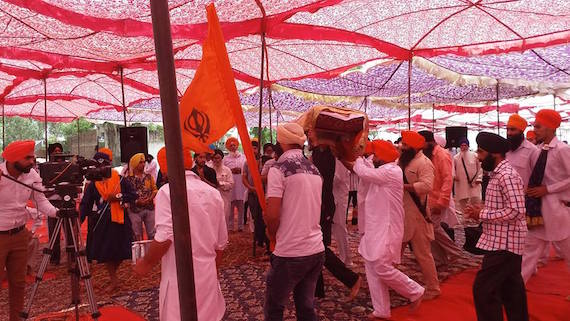 Saroop of Sri Guru Granth Sahib ji being brought to the pandal