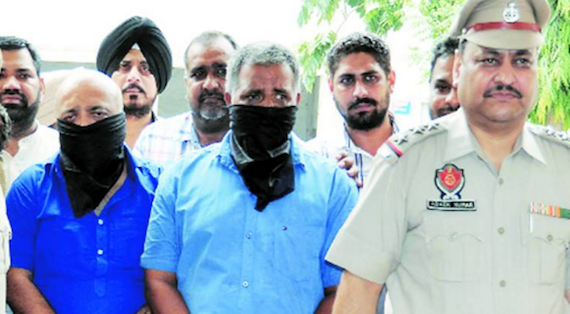 Amit Arora (Left) and his associate in police custody | Photo Source: Indian Express; Credits: Gurmeet Singh
