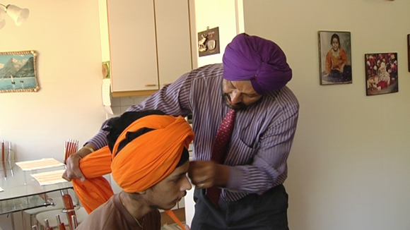 Sukhdarshan Singh Gill (Finland) helps his son to tie his turban